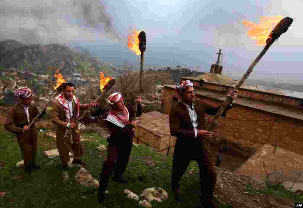 Iraqi Kurds holding lit torches walk up a mountain in the town of Akra, 500 kilometers north of Baghdad, as they celebrate the Norouz spring festival. (AFP/Safin Hamed)