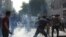 Protesters battle tear gas fired by police during a rally in Tehran on July 9.
