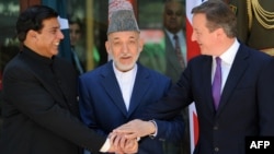 Afghan President Hamid Karzai (center), Pakistani Prime Minister Raja Pervez Ashfraf (left), and British Prime Minister David Cameron shake hands before a meeting at the Presidential Palace in Kabul on July 19.