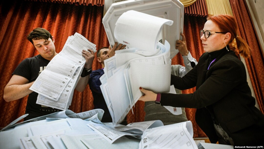 Members of a local electoral commission empty a ballot box at a polling station after the last day of parliamentary elections in Moscow on September 19. 