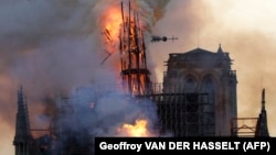 The spire of Notre Dame Cathedral collapses as smoke and flames engulf the iconic building in Paris on April 15. (file photo)