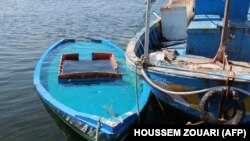A 2020. október 13-án készült képen egy 29 embert szállító, a tunéziai partoknál elsüllyedt csónakot vontatnak a tunéziai Amra parti város közelében. Előző este újabb holttestek kerültek elő. A vízbe fúltak száma tizenhárom, többen eltűntek