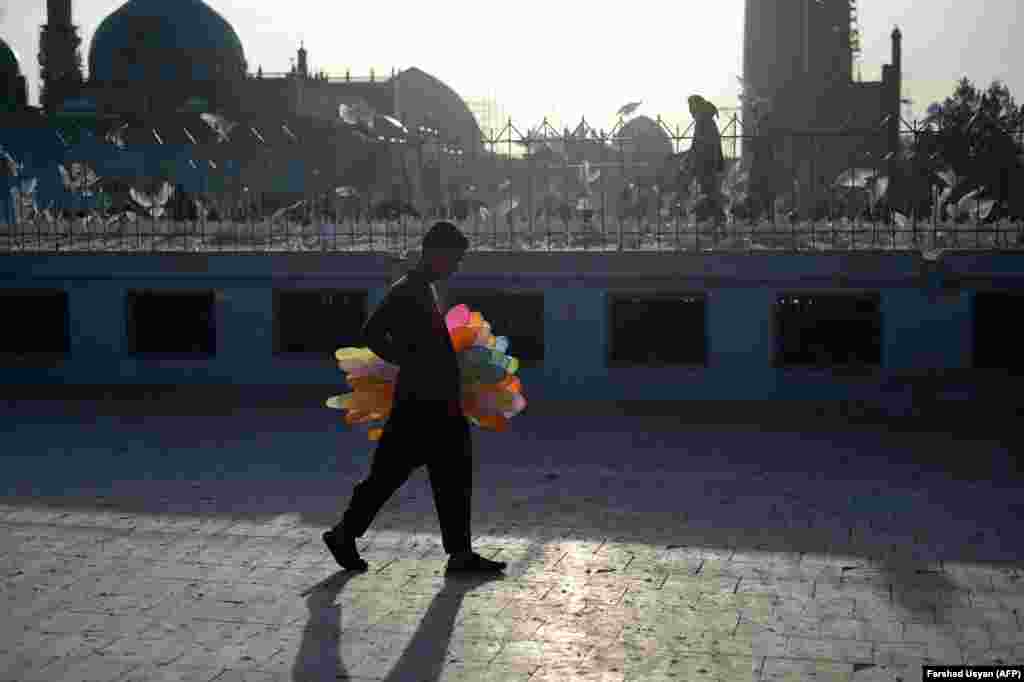 A young Afghan balloon vendor looks for customers in the courtyard of the Hazrat-e Ali Shrine, or Blue Mosque, in Mazar-e Sharif.&nbsp;(AFP/Farshad Usyan)&nbsp;