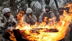 Новобранці 28-ї окремої механізованої бригади ЗСУ гріються біля багаття під час навчань перед бойовими завданнями. Харківщина, 26 лютого 2026 року