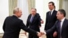 At the start of a meeting in the Kremlin, Russian President Vladimir Putin shakes hands with Josh Gruenbaum, commissioner of the U.S. Federal Acquisition Service. US President Donald Trump's special envoy Steve Witkoff points as Trump's son-in-law Jared Kushner looks on. January 22, 2026.
