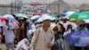 Pelegrinët myslimanë ecin me çadra për shkak të të nxehtit ekstrem gjatë haxhillëkut vjetor në Mina, Arabi Saudite, 18 qershor 2024.