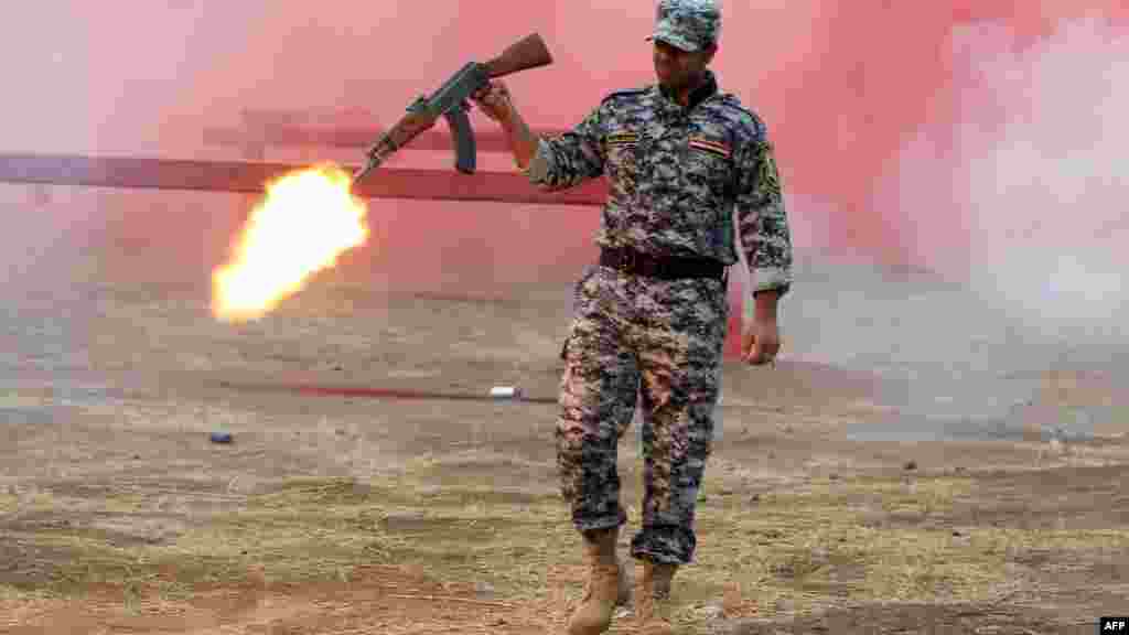 A police cadet fires his weapon during a graduation ceremony in Baghdad. (AFP/Ahmad al-Rubaye)