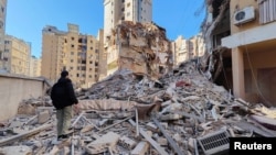A person stands on the rubble of a damaged building after an Israeli strike on Beirut's southern suburbs, following renewed hostilities between Hezbollah and Israel amid the US-Israeli conflict with Iran, in Lebanon on March 5.