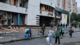 Люди залишають станцію метро «Лук'янівська», в якій переховувалися під час повітряної атаки РФ на Київ. Будівля метро пошкоджена цим та іншими російськими обстрілами
