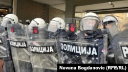 Detalj sa protesta ispred Skupštine Grada Novog Sada, u decembru 2024. Policija, u punoj opremi za razbijanje demonstracija, obezbeđivala je ulaz u zgradu, dok su demonstranti, koji su tražili ostavke gradskih čelnika, njihove štitove izlepili simbolom protesta - crvenim šakama.