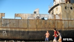 Kazakh children play on an abandoned ship in the dry bed of the Aral Sea.