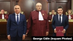 Actualul premier, Ilie Bolojan, la predarea mandatului către Nicușor Dan, la Curtea Constituțională a României, pe 22 mai 2025. În fundal, o parte dintre judecătorii care, pe 18 februarie 2026, au declarat constituțională Legea privind pensiile magistraților. 