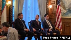 Uzbek Justice Minister Ruslanbek Davletov (left) and Capital Markets Development Agency Director Atabek Nazirov (right) speak to Baker McKenzie partner Thomas Firestone at the Uzbek Embassy in Washington on July 18. 