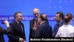 Syrian U.N. ambassador Bashar al-Jaafari (C) speaks with other participants during a session of the peace talks on Syria in Nur-Sultan, April 26, 2019