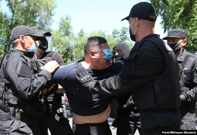 Мужчина в защитной маске задержан во время несанкционированного митинга сторонников казахстанской оппозиции в Алматы в июне 2020 года.