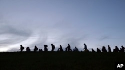 Német rendőrök kísérnek egy csoport migránst a német–osztrák határon, Passau közelében