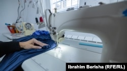 Një grua në strehimoren në Pejë, gjatë kursit të rrobaqepësisë, më 28 nëntor 2025.