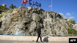 Гаванада Куба туы тігілген маңнан өтіп бара жатқан адам. Куба, 5 қаңтар, 2026 жыл.