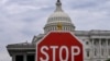 A stop sign is seen in front of the US Capitol dome in Washington, DC, on September 30, 2025.