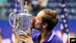 Russian tennis star Daniil Medvedev kisses the championship trophy after defeating Serbia's Novak Djokovic in the men's singles final of the U.S. Open on September 12, 2021, in New York City.