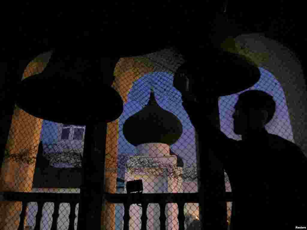 A bell ringer is silhouetted as he stands at the tower of a cathedral on Orthodox Christmas Eve in Bishkek on January 6. Some Orthodox Christians follow the old Julian calendar and celebrate Christmas on January 7. Photo by Vladimir Pirogov for Reuters