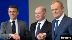 French President Emmanuel Macron (left to right), German Chancellor Olaf Scholz, and Polish Prime Minister Donald Tusk shake hands at a previous meeting of the Weimar Triangle at the Chancellery in Berlin.