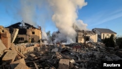 Pompierii lucrează la locul unde a avut loc un atac cu rachete rusești, în regiunea Harkov, Ucraina, 10 mai 2024.