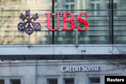 Logot e bankave zvicerane UBS dhe Credit Suisse shihen në Cyrih, 20 mars 2023.