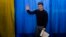 Volodymyr Zelenskyy waves to the media before casting his ballot at a polling station during the presidential election in Kyiv on March. 31.