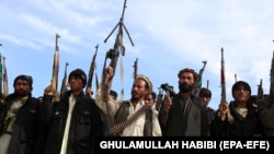 A pro-government anti IS volunteers brandish their weapons in eastern Afghanistan.
