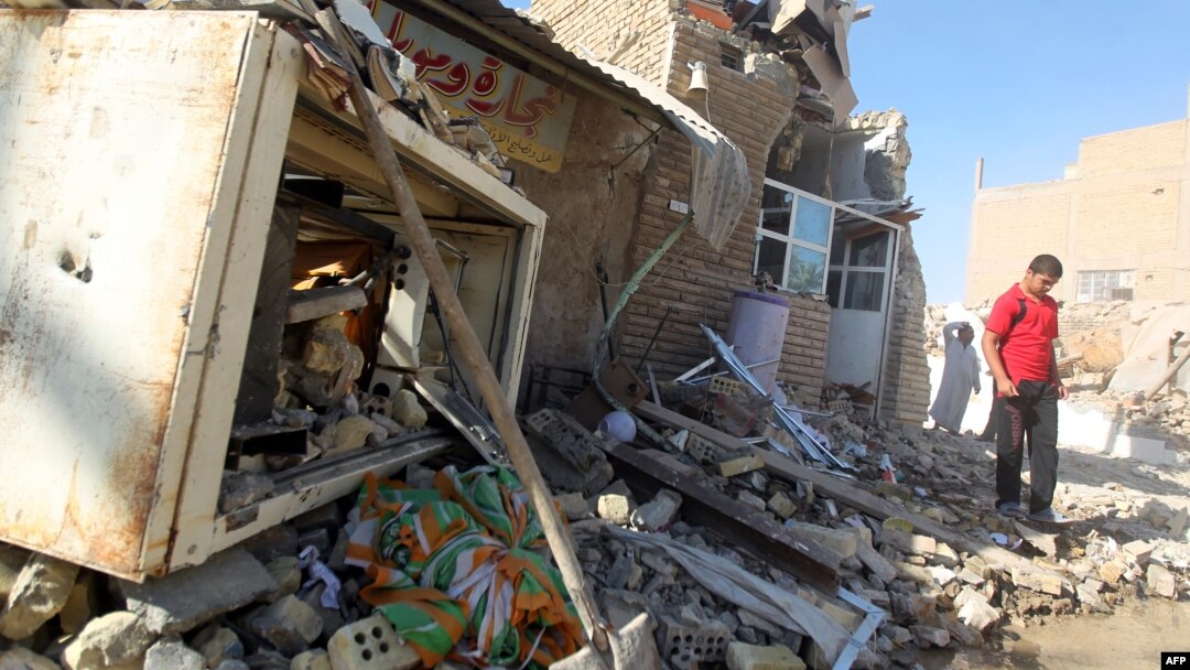 A man walks on the rubble of a mosque following an explosion near Baghdad amid an upsurge in violence. (file photo)