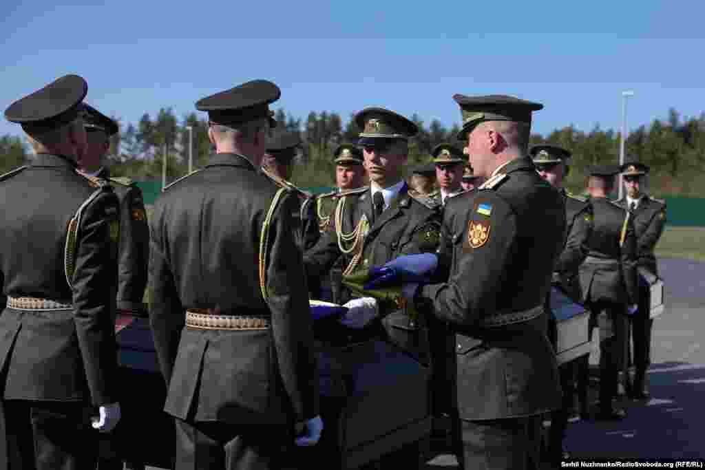 Після завершення церемонії поховальна група складає державні прапори України, які передаються визначеним особам. Кожен прапор пронумерований і відповідає труні