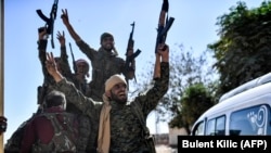 Members of the Syrian Democratic Forces (SDF), backed by U.S. special forces, celebrate at the front line in Raqqa on October 16.