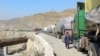 A man walks past trucks loaded with supplies to leave for Afghanistan after Taliban authorities closed the main border crossing in Torkham on February 21.