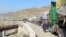 A man walks past trucks loaded with supplies to leave for Afghanistan after Taliban authorities closed the main border crossing in Torkham on February 21.