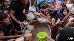 Copiii palestinieni primesc alimente la o școală ONU din Rafah., în sudul Fâșiei Gaza.