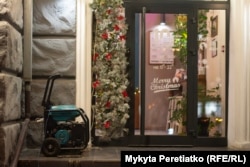 A generator outside a cafe decorated for the holidays in Dnipro on December 11.