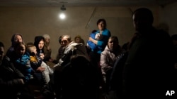 People hide in the basement of a church, which is being used as a bomb shelter, after fleeing from nearby villages that were attacked by the Russian Army, in the town of Bashtanka in Ukraine's Mykolayiv district on March 31