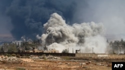 Smoke billows following air strikes by regime forces on rebel positions during intense fighting in Aleppo on August 18.