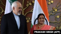 Indian Foreign Minister Sushma Swaraj (right) poses for photos with Iranian Foreign Minister Mohammad Javad Zarif prior to a meeting in New Delhi on May 14. 