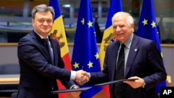 Moldovan Prime Minister Dorin Recean (left) shakes hands with European Union foreign policy chief Josep Borrell after a signing ceremony in Brussels on May 21.