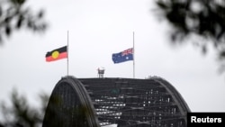 Steaguri în bernă pe emblematicul pod din golful de la Sydney, pe 15 decembrie 2025.