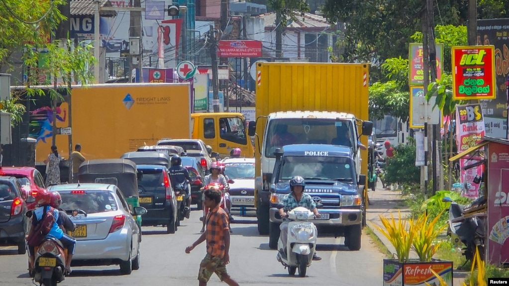 تصویری از همراهی خودرو پلیس با کامیون‌های حمل اجساد ملوانان کشته‌شدهٔ ناوشکن دنا