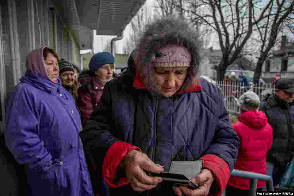 Svetlana Ivanovna, a widow, gets her documents ready at a humanitarian aid distribution center.