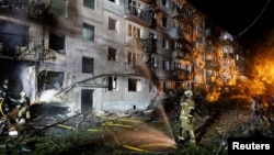 Firefighters work at the site of an apartment building hit by a Russian missile strike in Kyiv on August 1.