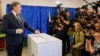 Presidential candidate Crin Antonescu smiles to media as he casts his vote in the first round of the presidential election redo in Bucharest on May 4.