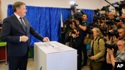 Presidential candidate Crin Antonescu smiles to media as he casts his vote in the first round of the presidential election redo in Bucharest on May 4.