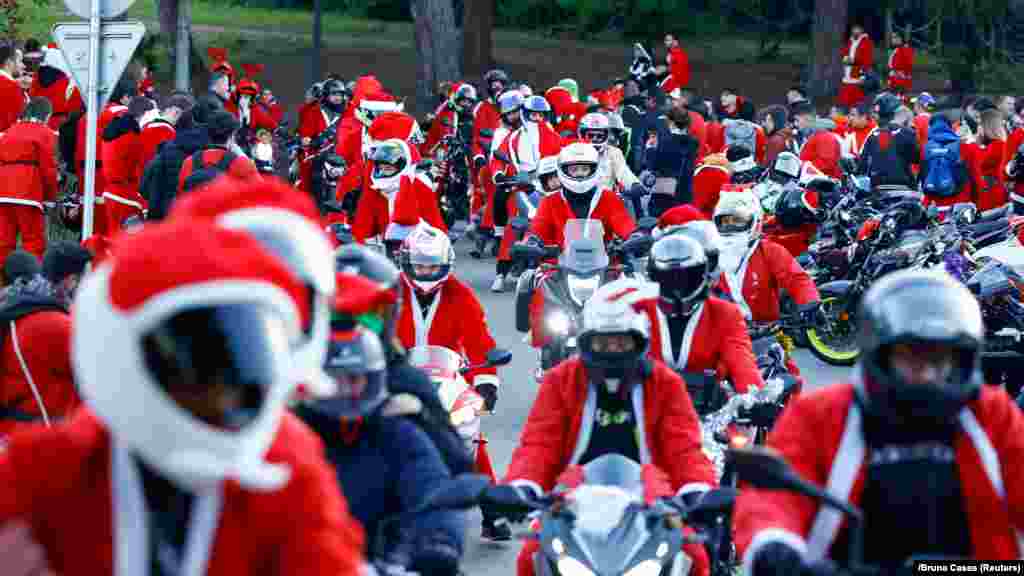 Stotine ljudi obučenih kao Deda Mraz paradiraju svojim motorima kroz Barselonu, Španija, 15. decembra 2024.