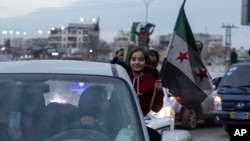 Syrians celebrate President Bashar al-Assad's ouster in Damascus on December 8.