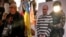Люди поруч із плакатом для фотографування, із зображенням воїна ЗСУ, який заарештовує очільника РФ Володимира Путіна. Мітинг з нагоди Дня Незалежності України, Варшава, 24 серпня 2026 року 